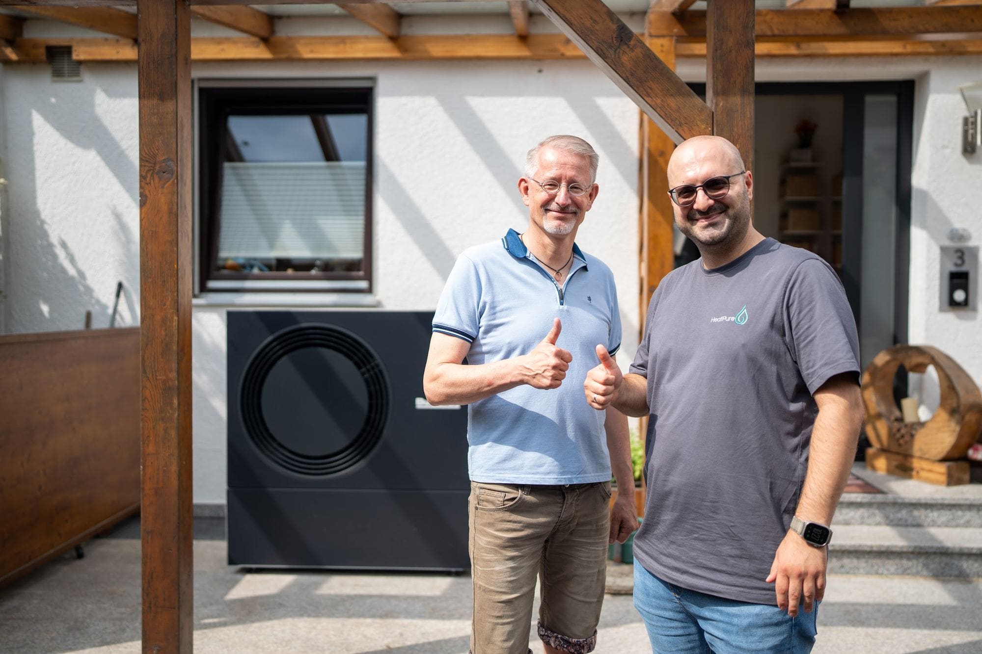 Zufriedener Kunde und Durmus Pekel von HeatPure vor der neuen Buderus-Wärmepumpe