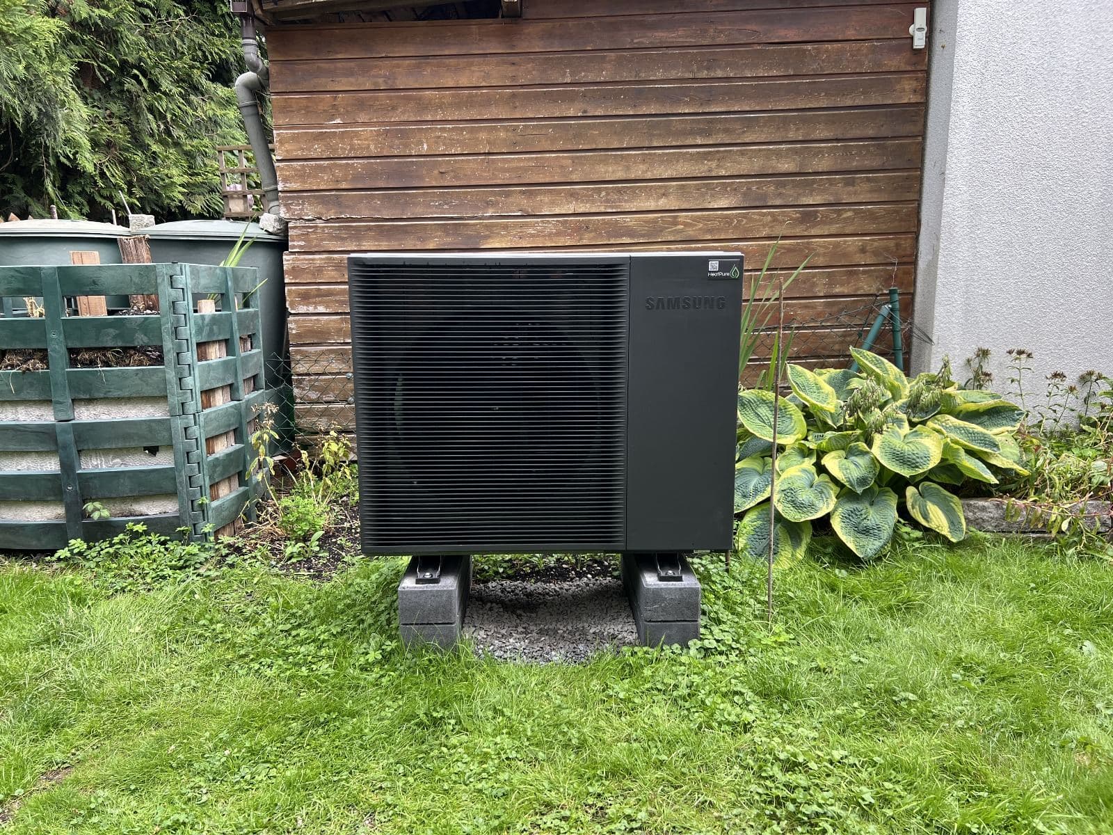 Wärmepumpen-Außeneinheit im Garten eines Hauses in Eichenau