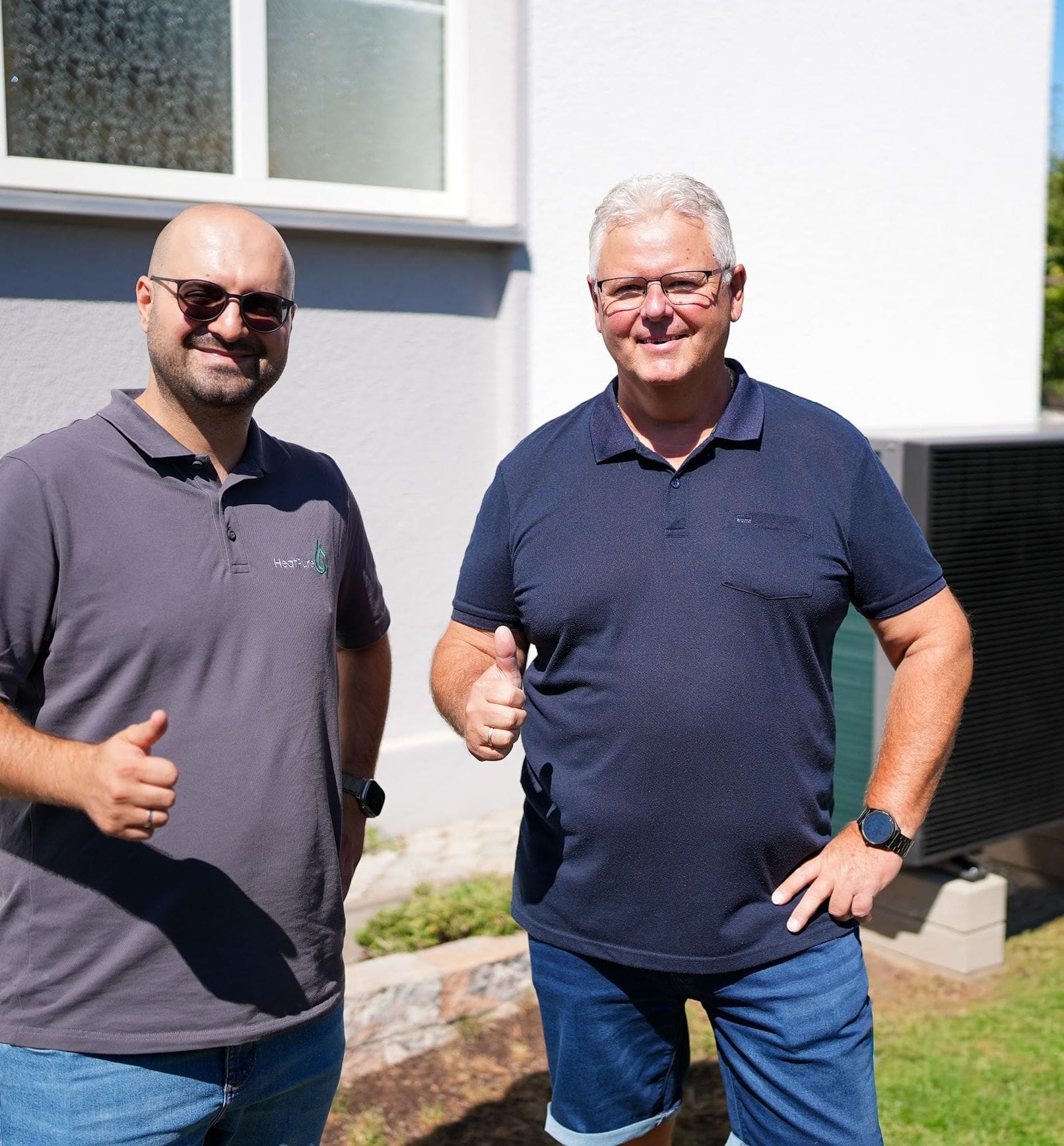 Durmus Pekel von HeatPure mit einem zufriedenen Kunden vor der neuen Wärmepumpe